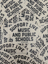 Stickers with 'Support Live Music and Public Schools' text on a beige background